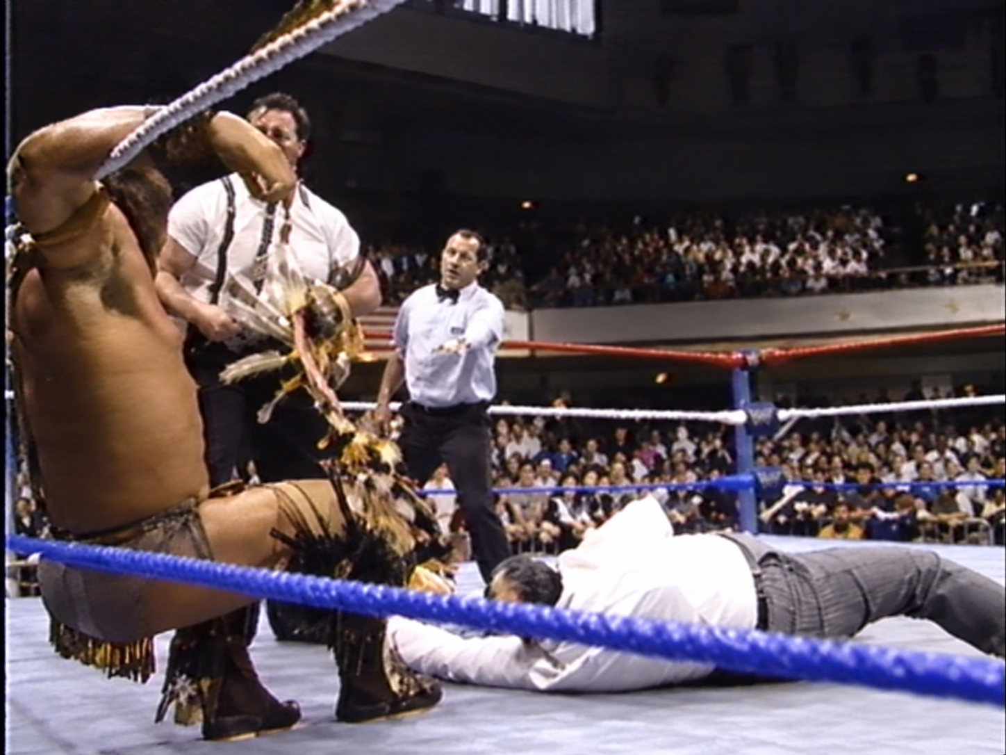 Tatanka trapped in the ropes as IRS destroys his ceremonial headdress.